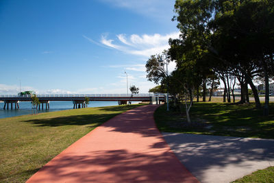 Footpath by bridge against sky