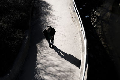 High angle view of man walking on footpath