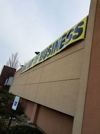 Low angle view of text on building against sky