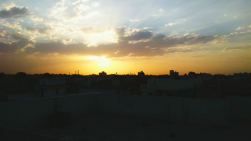 Silhouette cityscape against sky during sunset