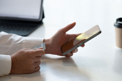 Midsection of person using laptop on table