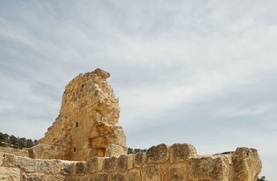 View of rock formation against cloudy sky