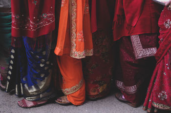 Low section of women wearing saris while standing on street
