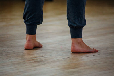 Low section of man standing on wooden floor