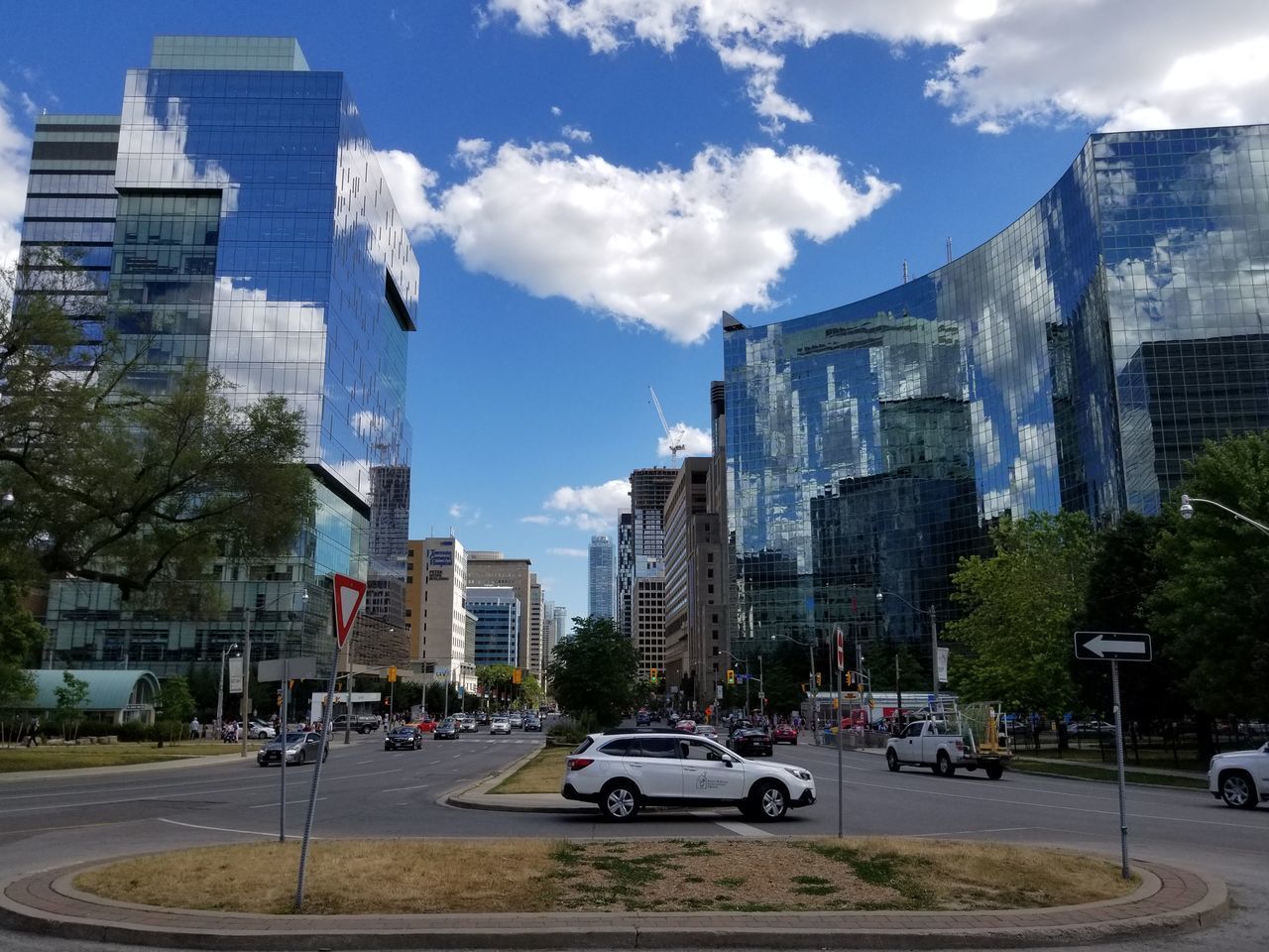 CARS ON STREET BY BUILDINGS AGAINST SKY