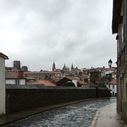 View of cityscape against cloudy sky
