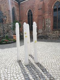 Cross on footpath against building in city