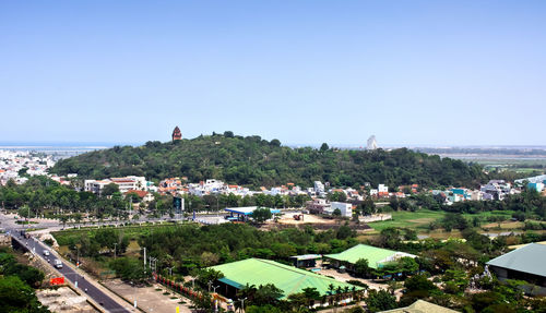 High angle view of buildings in town against clear sky