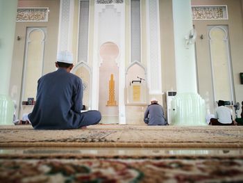 Rear view of men praying at mosque