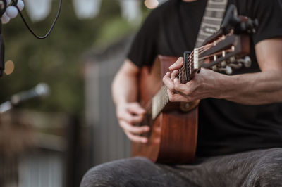 Cropped hand of guitarist playing guitar at music concert