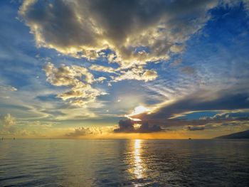 Scenic view of sea against dramatic sky during sunset