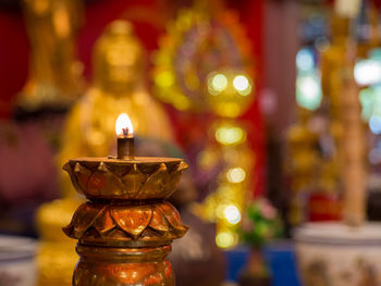 Close-up of illuminated light candles in temple