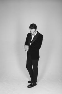 Full length of young man standing against white background
