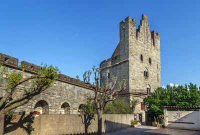 Low angle view of historic building against blue sky