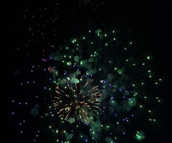 Low angle view of firework display at night