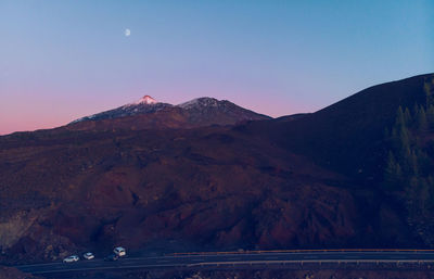 Scenic view of mountains against clear sky at sunset