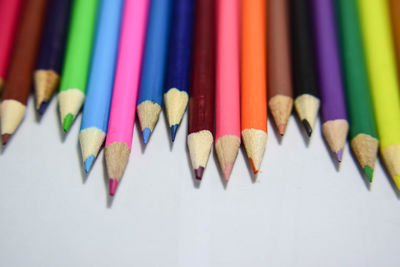 Close-up of colored pencils over white background