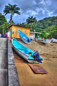 Boats moored on shore against sky