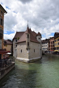 Canal amidst buildings against sky