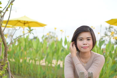 Portrait of woman standing against plants