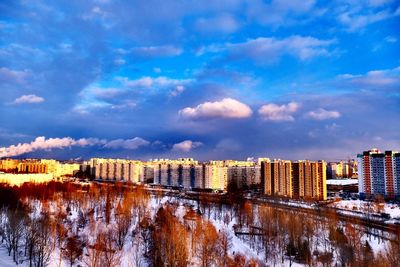 Panoramic view of river by city against sky during winter