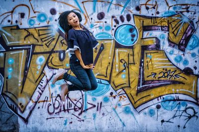 Full length of woman in graffiti on wall