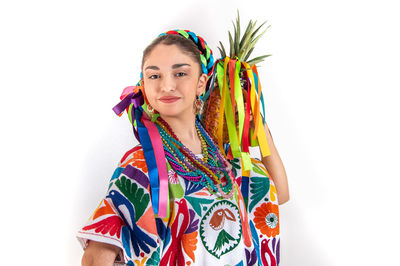 Portrait of smiling young woman against white background