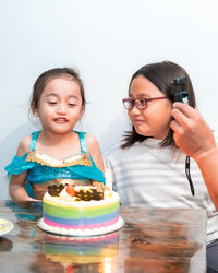 Little girl smiling and happy while celebrating at home with family during quarantine.