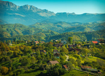 Scenic view of field and houses against mountains