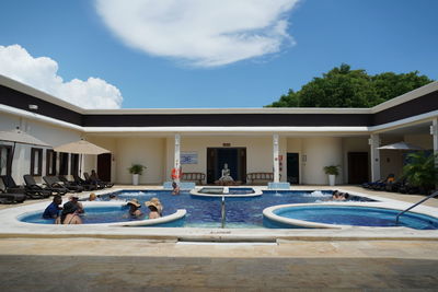 People in swimming pool against sky