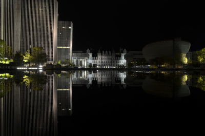 Reflection of buildings in lake at night