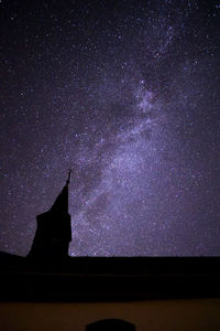 Low angle view of silhouette building against sky at night