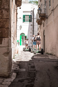 People on street amidst buildings in city