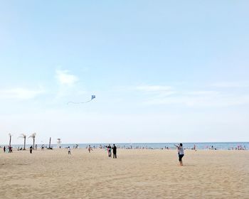 People at beach against sky