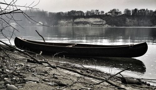 Boat moored at beach against sky