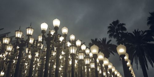 Low angle view of illuminated street lights against sky at night