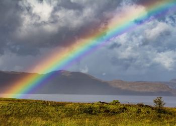 Rainbow over landscape against sky