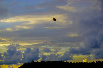 Low angle view of kite flying against sky during sunset