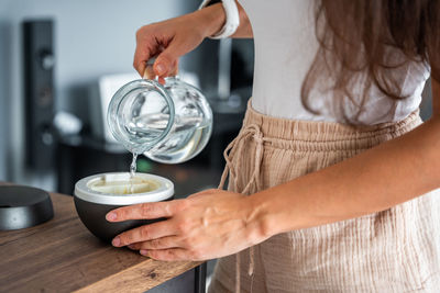 Midsection of woman holding coffee at table