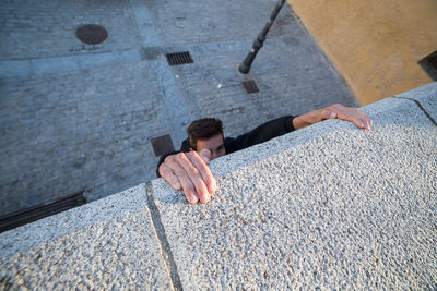 High angle view of man climbing on wall