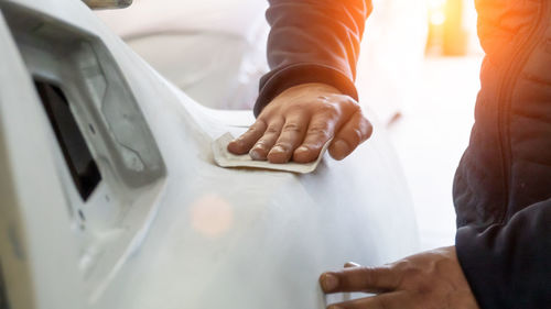 Midsection of man cleaning car