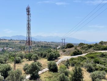 Electricity pylon on land against sky