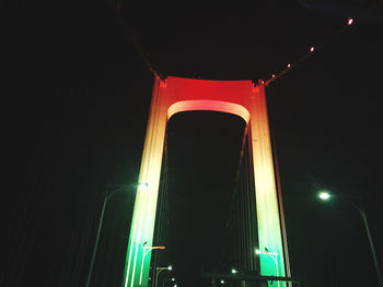 Low angle view of illuminated bridge against sky at night