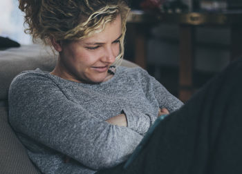 Close-up of woman watching video on digital tablet while sitting at home