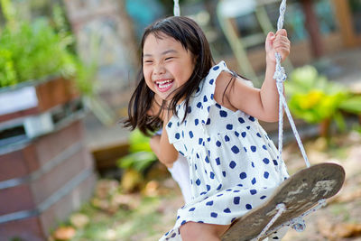 Portrait of young girl on swing