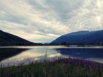 Scenic view of lake by mountains against sky