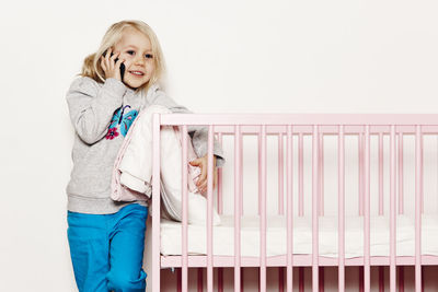 Girl near cot talking via cell phone