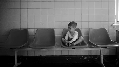 Boy looking away while sitting on chair
