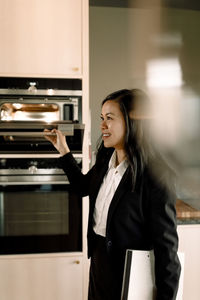 Real estate agent opening microwave in kitchen at new home