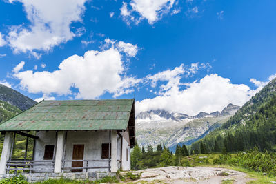 Panoramic view of the glaciers of the italian alps. old farm house in the foreground